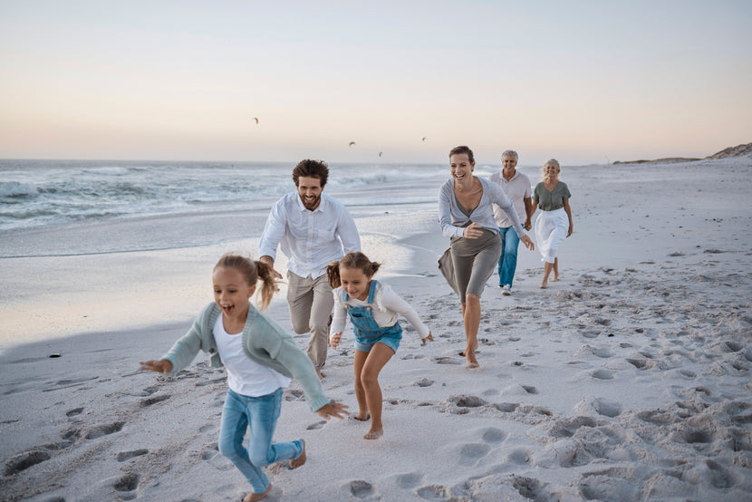 A family running happily along the beach