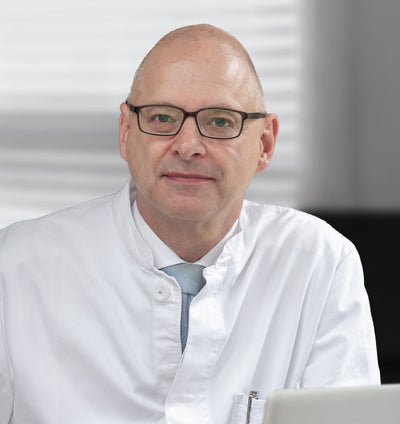 A man wearing glasses and a lab coat