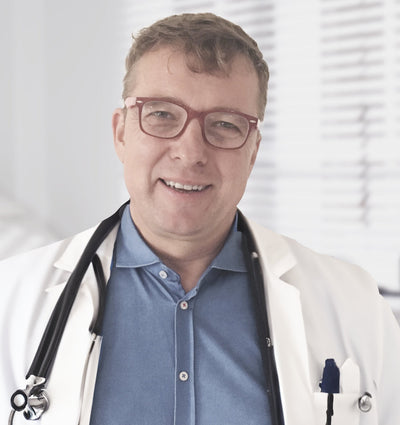 A man wearing glasses, stethoscope and a lab coat