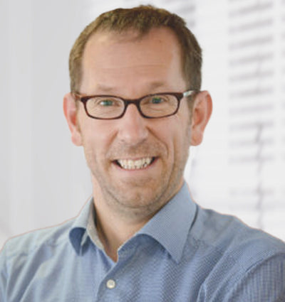 A smiling man wearing glasses